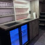 Moderne Kochnische mit Glasregalen, einer Arbeitsplatte und einem zweitürigen Minikühlschrank.